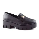Zapato mocasín negro de cuero sintético con plataforma track y detalle de hebilla dorada.