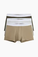 Pack de tres calzoncillos tipo trunk, confeccionados en punto elástico de algodón con tecnología Lycra® Xtra Life™. Incluye un par color beige, uno gris jaspeado y uno verde oliva, todos con cintura elástica blanca con franjas grises y parte delantera forrada.