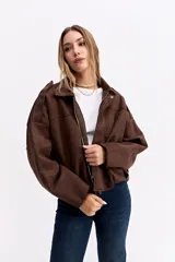 Campera de gamuza sintética color verde oliva, con silueta amplia, hombros caídos y cierre frontal. Presenta un diseño estructurado con volumen en mangas y cuerpo.