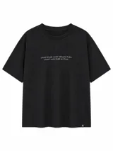 Remera negra de corte holgado y mangas cortas, con estampa frontal con la frase "CALM WALKS WITH FRIENDS TURN CHAOS INTO PURE RHYTHM".