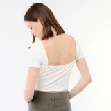 Camiseta corta de ajuste entallado, color blanco, con cuello redondo y mangas cortas.