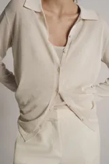 Chaqueta de punto de cuello polo y manga larga con cierre frontal de botones. Incluye un top interior a juego de escote redondo y tirantes finos.