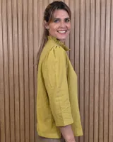 Camisa de algodón color blanco, con cuello alto con volados, mangas tres cuartos con detalles de bordado ingles y cierre frontal con botones de nácar.