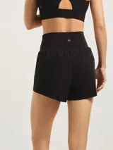 Short deportivo de color negro con calza biker integrada, confeccionado en tejido técnico ligero y elástico, con cintura alta y ajuste cómodo.