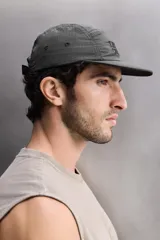 Gorra deportiva de estilo técnico confeccionada en tejido ripstop ligero, con estructura de cinco paneles y visera curva. Presenta el logo bordado en el panel frontal y ojales de ventilación laterales.