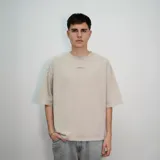 Remera beige de corte oversize con estampa en la espalda con la frase "venefoproject" en color marrón.