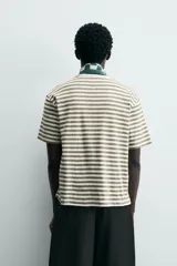 Camiseta de manga corta con cuello redondo y calce relajado, confeccionada en tejido de rayas horizontales blancas y negras.