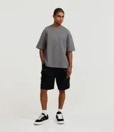 Bermuda masculina de algodón y poliéster, color negro, con cintura ajustable mediante lazo, bolsillos cargo laterales con cierre de cremallera y bolsillos traseros.