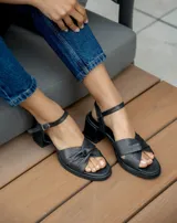 Sandalias de cuero color dorado, con plataforma y taco cuadrado. Presentan tiras cruzadas en el empeine y pulsera al tobillo con hebilla.