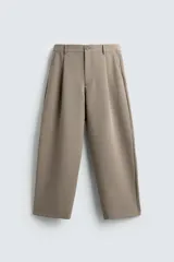 Pantalón de corte relajado en color verde militar, con diseño de pliegues frontales, bolsillos laterales y cierre de cremallera con botón.