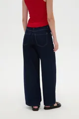 Pantalón jean azul oscuro, de tiro alto y corte ancho, con bolsillos y pespuntes en tono contrastante.