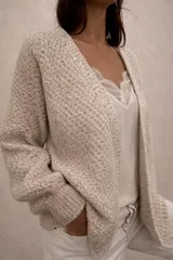 Cardigan de punto abierto con diseño melange, confeccionado en una mezcla de mohair y algodón. Presenta mangas largas con puños acanalados y un corte holgado.