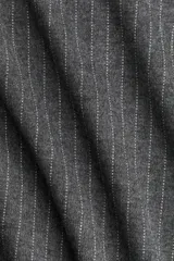 Vestido midi gris oscuro con finas rayas verticales blancas, escote drapeado tipo barco y mangas cortas caídas. Se ajusta a la cintura con un cinturón fino del mismo tejido y hebilla cuadrada.