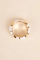 Anillo dorado con detalles de esmalte blanco.