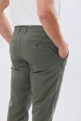 Pantalón de lino color beige, de corte recto y cintura elastizada con presillas para cinturón y bolsillos laterales.