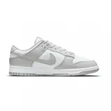 Championes Nike Dunk Low Retro, modelo de corte bajo con diseño bicolor en blanco y gris claro. Confeccionados con paneles de cuero, presentan el icónico swoosh lateral y suela de goma con patrón de tracción circular.