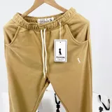 Pantalón de jogging color mostaza de algodón sin felpa, con cintura elástica ajustable con cordón, bolsillos laterales y puños elásticos en los tobillos.