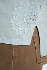 Remera marrón de algodón peinado flame, con escote en V, mangas cortas y diseño bordado de flores en tono sobre tono.
