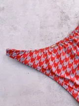 Bombacha de bikini vedetina con estampado de pata de gallo en tonos rojo y gris.