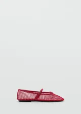 Zapato estilo bailarina color rojo, con diseño de rejilla, lazo decorativo y cierre de tira con hebilla.