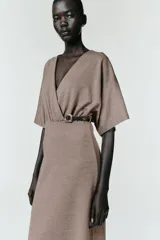 Vestido midi de escote en pico cruzado y manga corta. Presenta detalle de frunces en la cintura y un cinturón integrado con hebilla metálica a contraste.