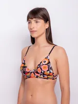 Top de bikini con estampado de flores multicolor, corte triangular fijo, breteles finos regulables, forro interior y copas desmontables.