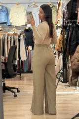 Pantalon sastrero de corte recto y tiro alto, color marrón con diseño de rayas verticales finas. Cuenta con cierre frontal con botón y bolsillos laterales.