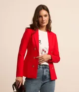 Blazer femenino de sastrería confeccionado en punto roma, con cuello solapa, cierre frontal con botones decorativos tipo escudo y bolsillos laterales. Presenta una estructura entallada y elegante.