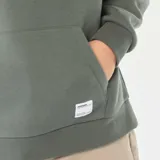 Buzo con capucha de corte holgado, color verde militar, con bolsillo frontal tipo canguro y cordones ajustables en el cuello.