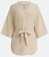 Kimono color crema de tejido viscolino con mangas anchas y lazo en la cintura.