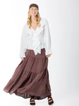 Blusa color blanco confeccionada en bambula liviana, con textura suave y caída fluida, escote en V con volados y mangas largas con puños elásticos.