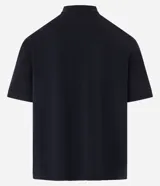 Remera de corte boxy confeccionada en algodón, con cuello polo y cierre frontal de botones. Presenta un diseño estampado en el frente con el número 93, una cruz y la palabra MAD en tipografía gótica.