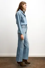 Jeans celeste de tiro alto, corte recto y largo, con cinco bolsillos y cierre frontal con cremallera y botón.