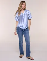 Camisa de algodón con rayas verticales en tonos verde, rosado y blanco. Tiene mangas cortas amplias, escote en V con solapa y botones frontales, y detalle de nudo en el bajo.