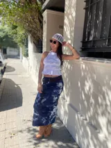 Falda larga de tiro alto con estampado tie-dye en tonos azul y blanco. Presenta un cinturón ancho marrón con cordones cruzados.