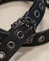 Cinto de dama de símil cuero negro, con ojales metálicos y una hebilla grande con diseño ornamental de estilo western.