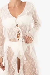 Vestido playero largo de encaje blanco con volados, mangas largas, abertura frontal con lazos para cerrar y aberturas laterales.