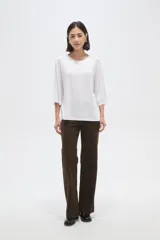 Remera de viscosa en color verde oliva, con cuello redondo y mangas 3/4. Presenta un diseño de tejido acanalado y corte holgado.