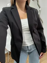 Blazer sastrero de corte clásico en color negro, con solapas de muesca, cierre frontal de un botón y bolsillos laterales con solapa.