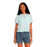 Remera deportiva de mujer New Balance, color celeste claro, con cuello redondo, mangas cortas y logo de la marca estampado en el pecho.