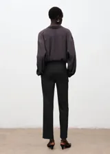 Pantalón de vestir gris oscuro con diseño de sutiles rayas verticales, corte recto y bolsillos laterales.