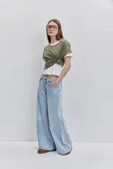 Jean wide leg de tiro medio y lavado claro, con silueta amplia y diseño clásico de cinco bolsillos, presillas para cinto y cierre frontal con botón y cremallera.