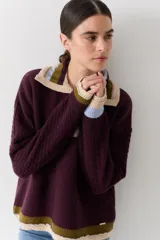 Buzo de lana tipo polo con cuello y cartera de botones en colores contrastantes. Presenta mangas con textura de ochos y puños y ruedo con terminaciones en franjas de colores.