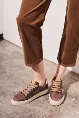 Pantalón de pana color beige, tiro medio, corte recto y largo al tobillo.