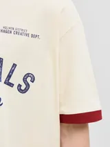 Remera de manga corta y cuello redondo, color blanco antiguo, con ribetes bordó en cuello y mangas. Presenta un estampado frontal con la palabra "ORIGINALS" y "studio" en azul marino, junto a pequeños textos y el número "1990".