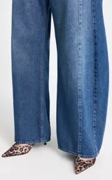 Jean de tiro alto con corte wide leg, confeccionado en denim azul clásico. Presenta costuras verticales frontales que estilizan la silueta y un diseño de pierna ancha.