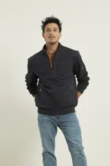 Campera estilo bomber color verde oscuro, con cierre metálico, dos bolsillos externos con cierre y un bolsillo interno.