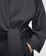 Blusa gris de corte cruzado tipo cache-coeur, con escote en V, mangas largas y detalle de lazo para atar en el lateral de la cintura. Confeccionada en mezcla de liocel y poliéster.