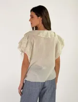 Blusa bordó de manga corta con escote en V y volados en cascada que rodean el cuello y el frente.