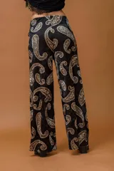 Pantalón de corte recto y holgado confeccionado en terciopelo negro con estampado de arabescos en tonos dorados y marrones.